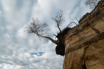 Limestone beach at the Baltic Sea with beautiful sand pattern and vivid red and orange color - Tourist writings on the walls and rocks and sand - Veczemju Klintis, Latvia - April 13, 2019
