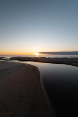 Fototapeta premium Red vivid sunset at the Baltic Sea with mirror like water - Veczemju Klintis, Latvia - April 13, 2019