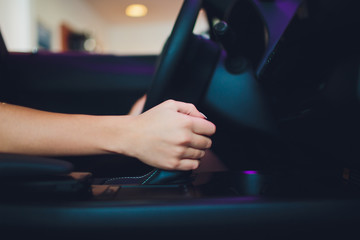 Female hand on automatic transmission lever, close up.