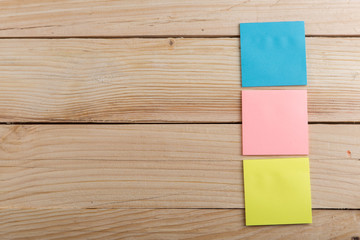 Many colorful sticky note on wooden desk. Copy space