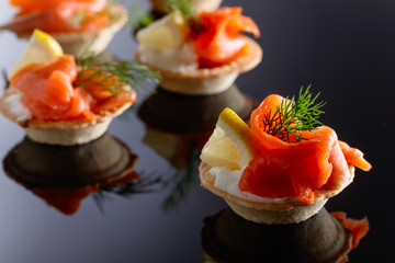 Tartlets with salmon , cream and a slice of lemon.