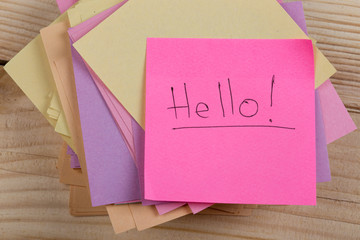 greeting concept - Stickers with the words "Hello" on wooden background