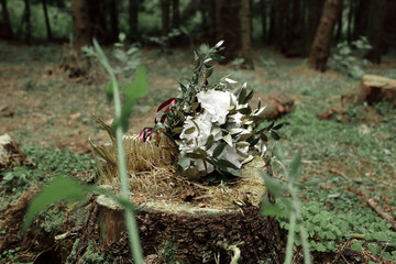 floral arrangement on a stump in the woods