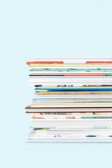 Close view of Stack of children's books on a pastel blue background.