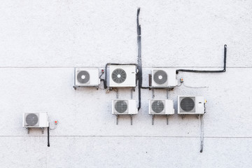 Air conditioning condensers on white wall refrigerant gas pipe