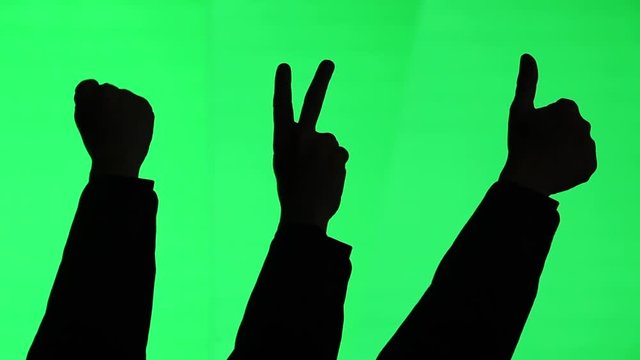 Three silhouettes. A fist pump. A peace or victory sign. A thumbs up. All on green screen background.
