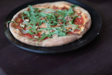 The tasty pizza on the beautifull plate in cafe