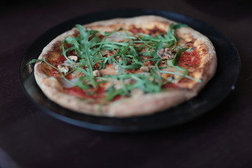 The tasty pizza on the beautifull plate in cafe