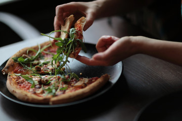 The tasty pizza on the beautifull plate in cafe