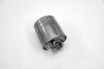 Spare part of the car fuel filter for cleaning gasoline and diesel before getting into the engine close-up on a white isolated background to perform vehicle maintenance in auto service.
