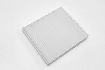 Close-up on a car filter for a white engine as a background with vertical stripes. Spare parts for vehicles, repairs and maintenance.
