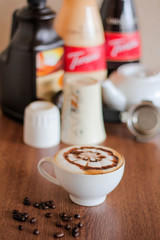Coffee latte with beautiful design on top, coffee beans background