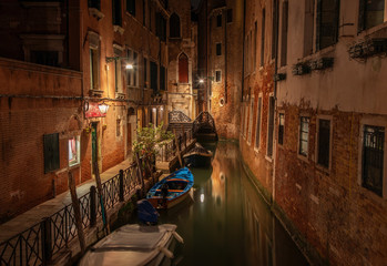 Narrow canal among beautiful old brick houses in Venice