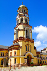 Fototapeta na wymiar Yellow tower of the church with a golden dome and clock