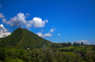 Single hill with blue sky and clouds