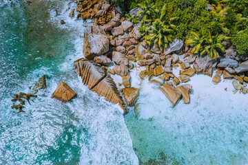 Anse Cocos beach tropical island La Digue Seychelles. Drone aerial view of foam ocean waves rolling...