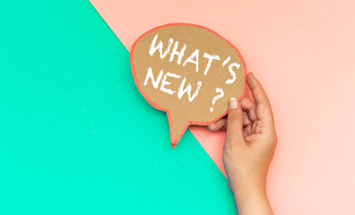 closeup hand holding what's new ? speech bubble