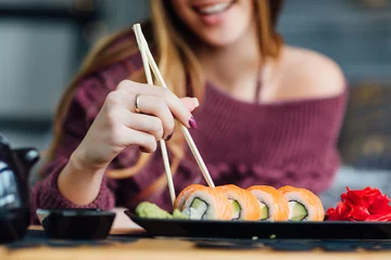 Tuinposter Sushi bar Weekendontbijt. vrouw voelt zich uitgerust en geniet van weekendontbijtsushi.