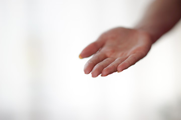 female hand with palm up on a light background