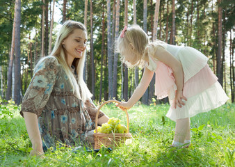 Pregnant young mother with her little daughter outdoors