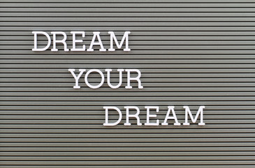 Dream your dream, text written with white plastic letters on metal board