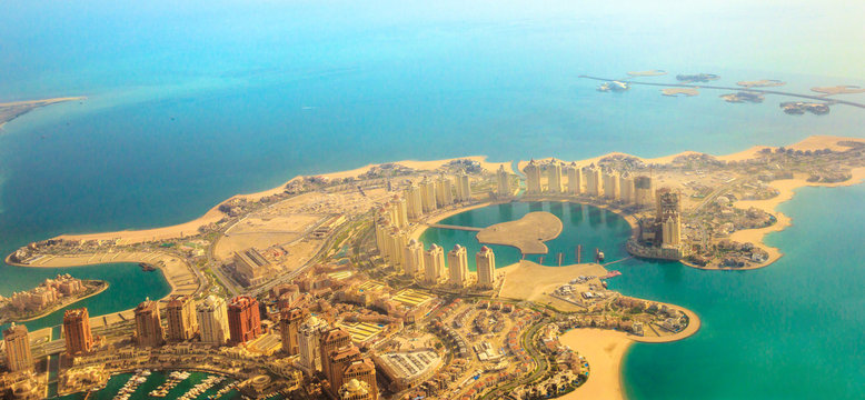 Aerial view of the Pearl-Qatar, the artificial island in Persian Gulf, Doha, Qatar, Middle East. Scenic flight of Viva Bahriya in Maghreb and Moorish style and exclusive Dana Island. Banner panorama.