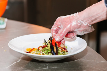 The process of cooking seafood salad: shrimp, mussels, cabbage, sauce, vegetables, tomatoes