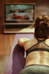 sports woman watching fitness videos on internet via laptop