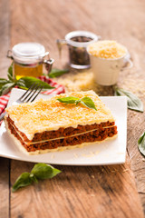 Lasagna close-up. Background in soft and warm colors, decorated with elegant red and white fabrics.