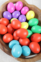 Multicoloured Easter eggs in a large wooden bowl