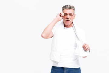 Smiling senior man in T-shirt on neck towel background..