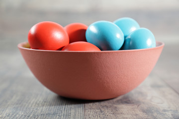 Multicoloured Easter eggs in a clay bowl