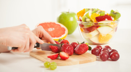 Unrecognizable woman's hands cutting strawberries