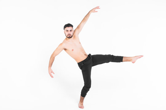 Modern ballet dancer posing over white background , wearing at casual pants.