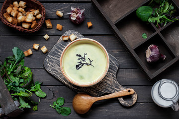 Creamy soup puree with spinach on a dark background