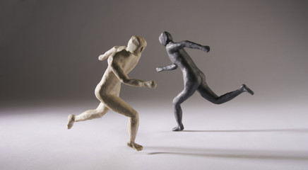 Black and white men run in different directions. With space copy  text. Isolated on grey background. Studio Shot.