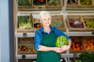 Senior woman working in small grocery store