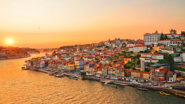 Beautiful skyline of portuguese city Porto taken during amazing sunset. Captured on 16:9 picture. The city center and the Porto Cathedral are in orange sunset light. 