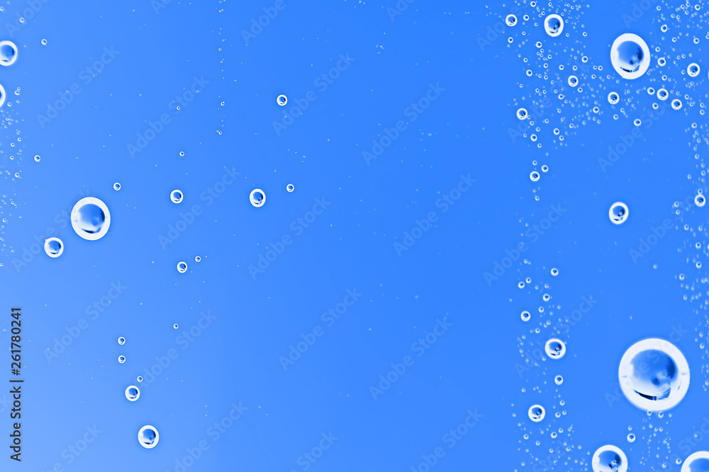 Wall mural fresh drops background blue glass / wet rainy background, water drops transparent glass blue