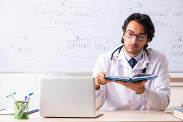 Young male doctor neurologist in front of whiteboard 