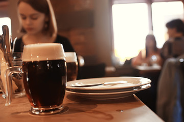 beer mug on a blurred background / beer restaurant beautiful dark beer in a mug in the interior of a pub