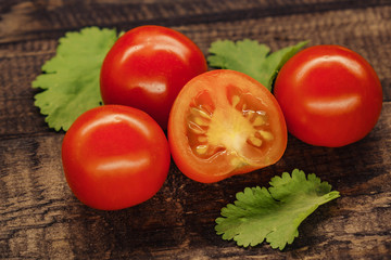tasty red cherry tomatoes on wooden background.