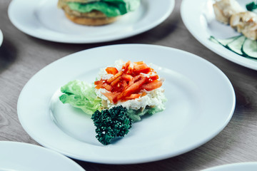 hamburger, vegetable salad and other dishes on the table in the restaurant