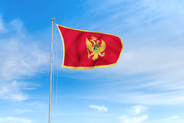Naklejka na ściany i meble Montenegro flag over blue sky background