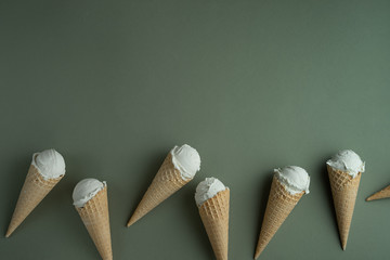 Homemade ice cream in a waffle cones on green background. Copy space for a text