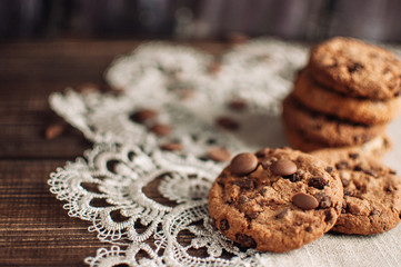 Chocolate chip cookies with green napkin on a wooden table.