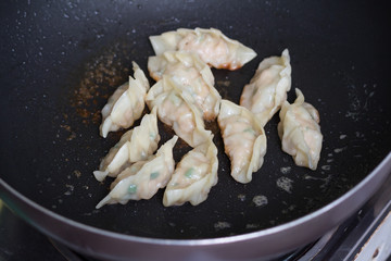 fried dumplings Gyoza with pork stuff during cooking on a pan