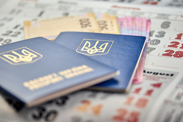 passports with national currency paper money close up view of cash on a calendar background