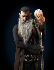 Evil Warlock old wizard posing with staff on a dark background. 3d rendering