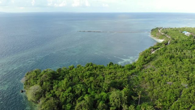 Aerial: Flying over tropical beach turquoise water coral reef , Tomia island Wakatobi National Park Indonesia Maldives Polynesia white sand beach. Native cinelike D-log color profile